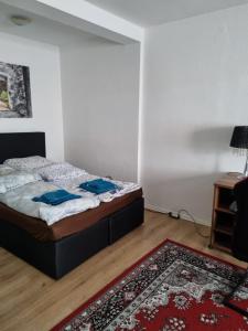 sypialnia z łóżkiem i czerwonym dywanem w obiekcie Glücks Ferienwohnungen w mieście Bremerhaven