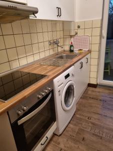 a kitchen with a sink and a washing machine at Glücks Ferienwohnungen in Bremerhaven