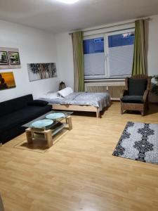 salon z łóżkiem i kanapą w obiekcie Glücks Ferienwohnungen w mieście Bremerhaven