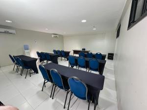uma sala de conferências com mesas pretas e cadeiras azuis em SLZ Lagoa Hotel em São Luís