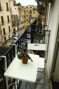 un tavolo bianco e sedie su un balcone con piante di Casa Nica a Palermo