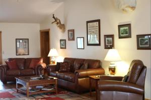 - un salon avec des canapés en cuir brun et une table dans l'établissement River Ridge Inn, à Norfork
