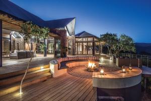 a house with a wooden deck with a fire pit at Kariega Game Reserve Settlers Drift in Alexandria