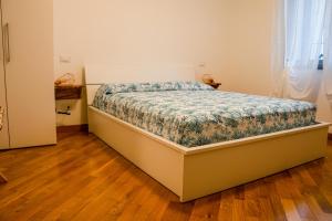 Villa Essenza - Rooms and Breakfast في ألبينغا: غرفة نوم مع سرير مع لحاف من الزهور
