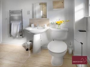 a white bathroom with a toilet and a sink at Jennett's Park, Bracknell - 2 Bedroom Home in Bracknell +8 photos