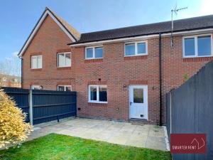 a brick house with a white door and a fence at Jennett's Park, Bracknell - 2 Bedroom Home in Bracknell