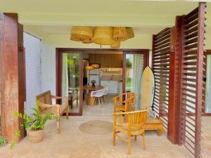 um quarto com cadeiras e uma prancha de surf num pátio em Taíba Beach Resort por Be My Guest! em São Gonçalo do Amarante