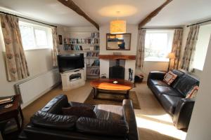 a living room with a leather couch and a table at Bassenthwaite Cottage, Bassenthwaite in Bassenthwaite