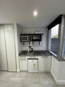 a small kitchen with a stove and a microwave at Hermoso apartamento en el corazón de Palermo - Cerca de todo in Buenos Aires