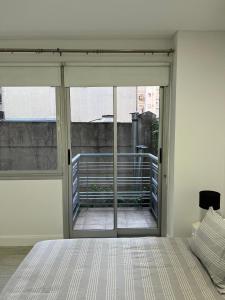 a bedroom with a large sliding glass door to a balcony at Hermoso apartamento en el corazón de Palermo - Cerca de todo in Buenos Aires