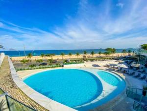 uma vista para uma piscina e para a praia em Hotel Nacional rj no Rio de Janeiro