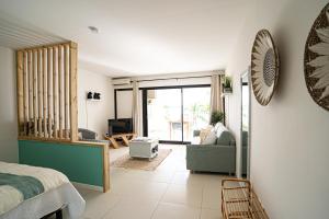 Superb Studio Lagoon View في باي نيتل: غرفة نوم مع سرير وغرفة معيشة مع أريكة