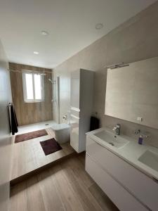 a white bathroom with a sink and a toilet at Axtart Penthouse with Amazing Views in Marsaxlokk