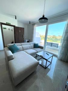 a living room with a couch and a large window at Axtart Penthouse with Amazing Views in Marsaxlokk