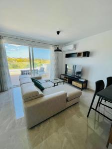 a living room with a couch and a television at Axtart Penthouse with Amazing Views in Marsaxlokk