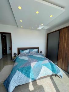 um quarto com uma cama com uma colcha azul e branca em Axtart Penthouse with Amazing Views em Marsaxlokk