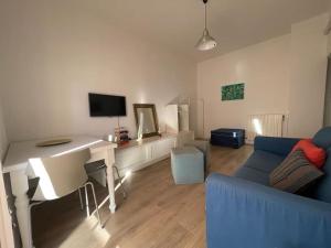 sala de estar con escritorio y sofá azul en Casa “V” en San Remo