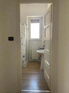 ein weißes Bad mit einem Waschbecken und einer Dusche in der Unterkunft Casa “V” in Sanremo