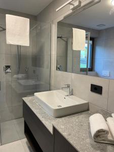 La salle de bains est pourvue d'un lavabo blanc et d'un miroir. dans l'établissement Apartment Malfi, à Fiè