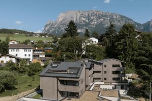 a house in a city with a mountain in the background at Apartment Malfi in Völs am Schlern