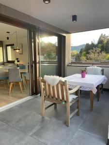 une table et un banc dans une chambre avec une table et un balcon dans l'établissement Apartment Malfi, à Fiè