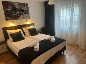 a bedroom with a large bed with towels on it at Hotell City Karlshamn in Karlshamn
