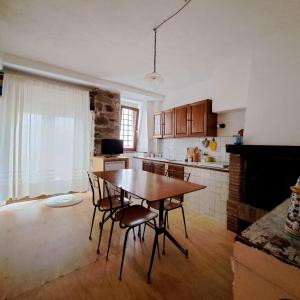 - une cuisine avec une table et des chaises dans la chambre dans l'établissement Loft antico La casina di Paola, à Seggiano