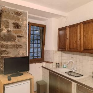 a kitchen with a sink and a tv on a counter at Loft antico La casina di Paola in Seggiano