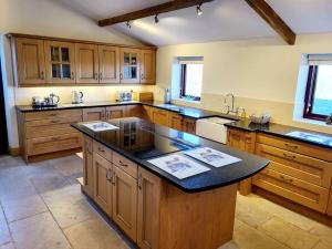 a large kitchen with wooden cabinets and a black counter top at Meadow View in Aysgarth