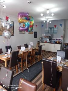 ein Restaurant mit Holztischen und einem großen Ballon Nr. 6 in der Unterkunft Rossall House , For Families & Couples in Blackpool