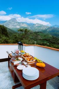 uma mesa com pratos de comida com montanhas ao fundo em Donce Extremo em San Carlos