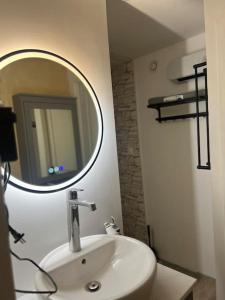 uma casa de banho com um lavatório branco e um espelho. em Un été sans fin em Lauris