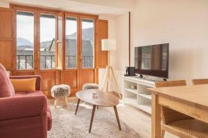 a living room with a couch and a table and a tv at La Solanda de Sallent in Sallent de Gállego