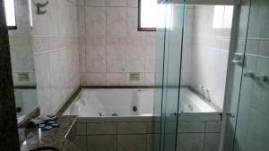 y baño con bañera y ducha acristalada. en North Palace Hotel, en São Paulo
