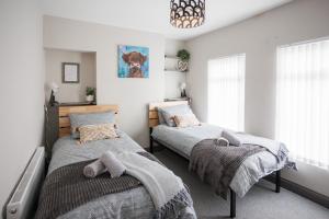 une chambre avec deux lits et un lustre dans l'établissement Belfast Townhouse, à Belfast