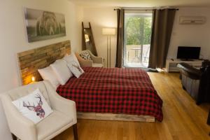 um quarto com uma cama, um sofá e uma cadeira em Condo Hotel Au pied du Mont Orford em Orford