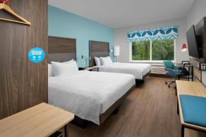 a hotel room with two beds and a tv at Tru By Hilton Jacksonville Airport in Jacksonville +42 photos