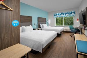 a hotel room with two beds and a tv at Tru By Hilton Jacksonville Airport in Jacksonville