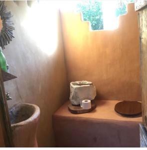 a small bathroom with a toilet and a sink at La Aldea Hostel, Camping y Hamacas in Palomino