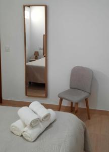 a bedroom with a bed and a mirror and a chair at TRANQUILO APARTAMENTO ZONA CENTRO in Alcalá de Guadaira +9 photos