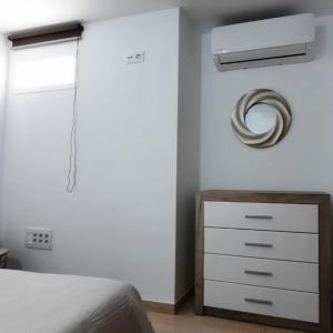 a bedroom with a bed and a dresser at TRANQUILO APARTAMENTO ZONA CENTRO in Alcalá de Guadaira