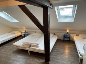 um quarto no sótão com 2 camas e 2 janelas em Clown and Bard Hostel em Praga