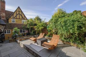 three chairs sitting on a patio in front of a house at Beautiful 1-Bed Studio in Saffron Walden in Saffron Walden