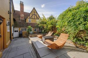 un patio con sillas, una mesa y una casa en Beautiful 1-Bed Studio in Saffron Walden en Saffron Walden
