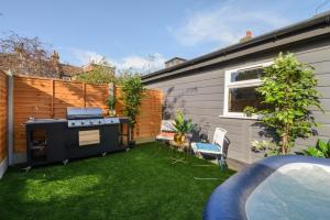 a backyard with a grill and green grass at Captivating 2-Bed Apartment in London in London