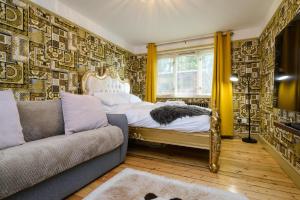a bedroom with a bed and a couch at Deluxe 1 Bed Flat Hot Tub Sky Tv in Saffron Walden