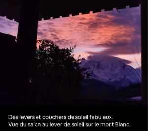 ein Fenster mit Blick auf einen Berg mit Sonnenuntergang in der Unterkunft La terrasse du mont Blanc in Cordon