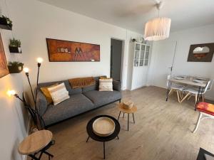 een woonkamer met een bank en een tafel bij La Guy’toune in Varaville