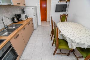 una pequeña cocina con mesa y fregadero en Apartments Vinka en Trogir