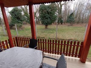 a porch with a table and chairs and a view of a field at SZEKI Apartman in Gyula